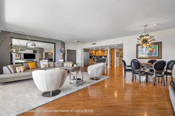 a living room with dining room and couches with wooden floor
