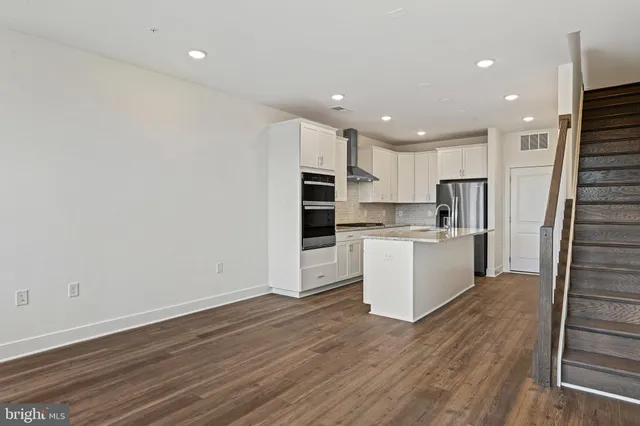 a view of kitchen with wooden floor and electronic appliances