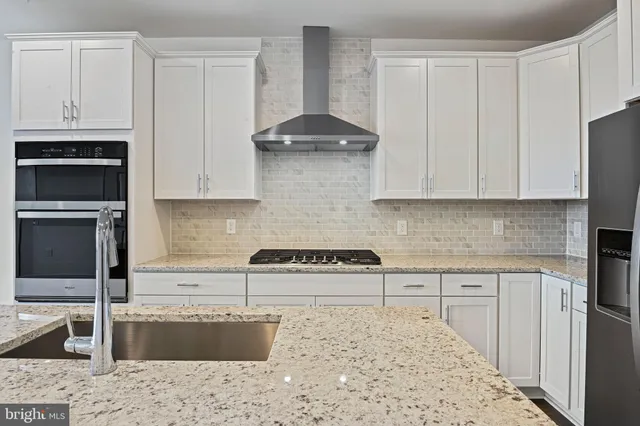 a kitchen with granite countertop a sink and a stove top oven