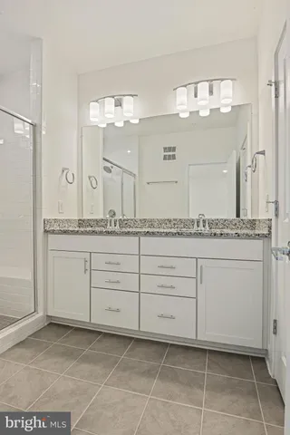 a bathroom with a granite countertop sink a mirror and a