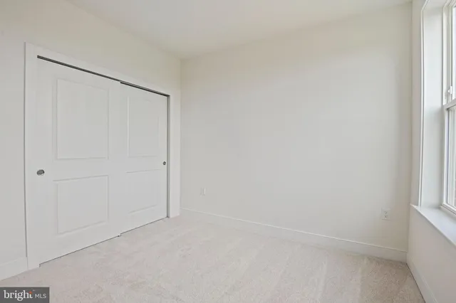 an empty room with windows and closet