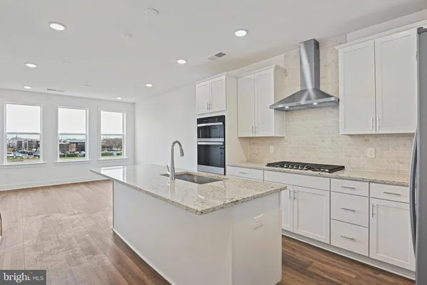 a kitchen with stainless steel appliances granite countertop a stove and a sink