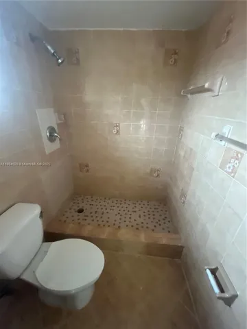 a bathroom with a toilet and a shower