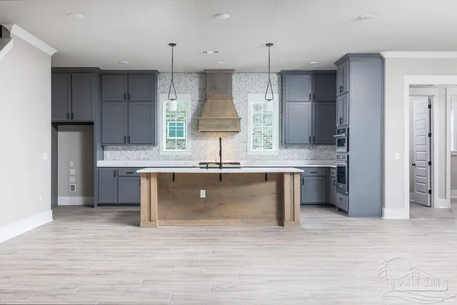 a kitchen with kitchen island a sink stainless steel appliances and cabinets