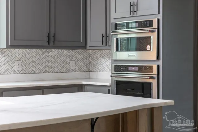 a kitchen with granite countertop a stove oven and white cabinets