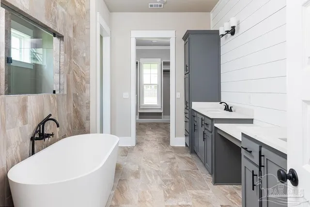 a bathroom with a tub sink and mirror