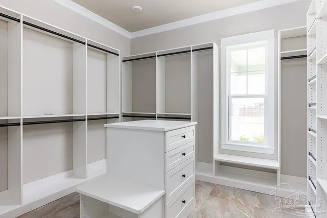 a view of walk in closet with clothes