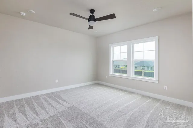 an empty room with a ceiling fan and window