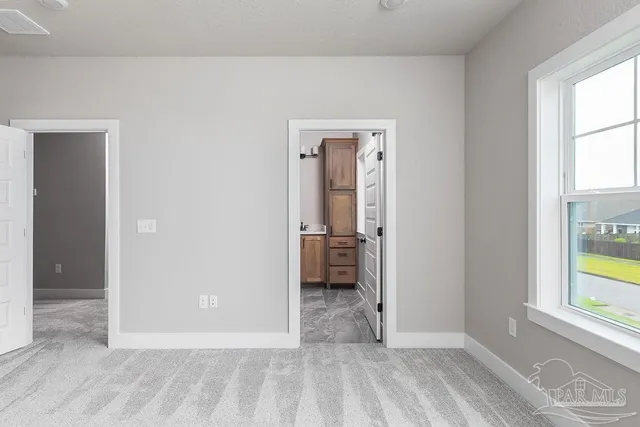 an empty room with windows and a bathroom