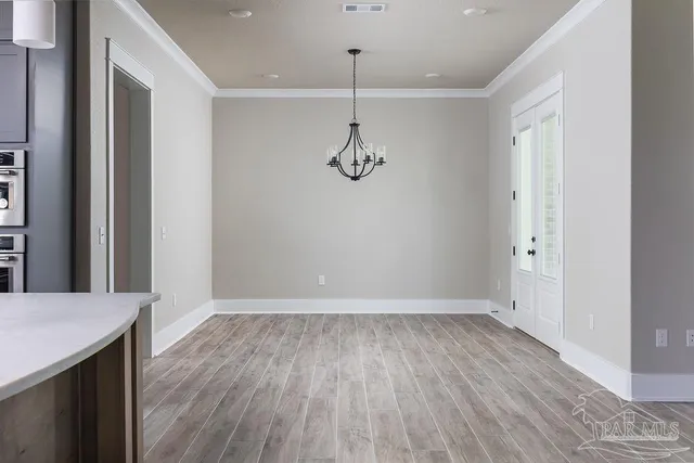 a view of a room with wooden floor and white walls