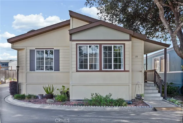 a view of a house with a yard and potted plants