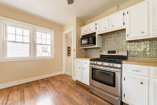 645 Normal Road DeKalb, IL 60115 - Photo 7 of 24 a kitchen with cabinets wooden floor and stainless steel appliances