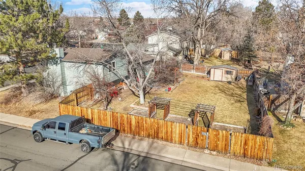 a backyard of a house with wooden fence and large trees