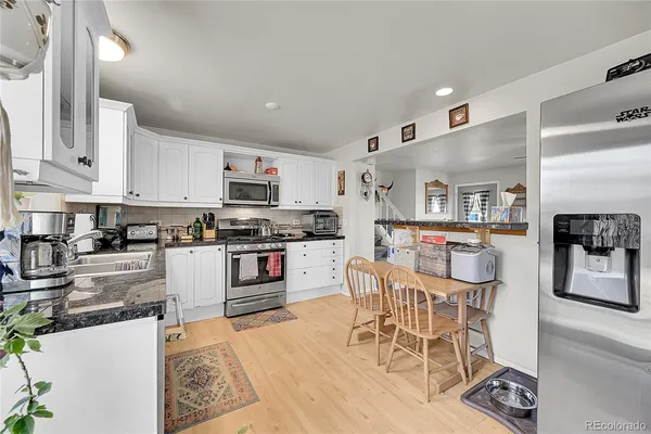a kitchen with stainless steel appliances kitchen island granite countertop a sink and cabinets