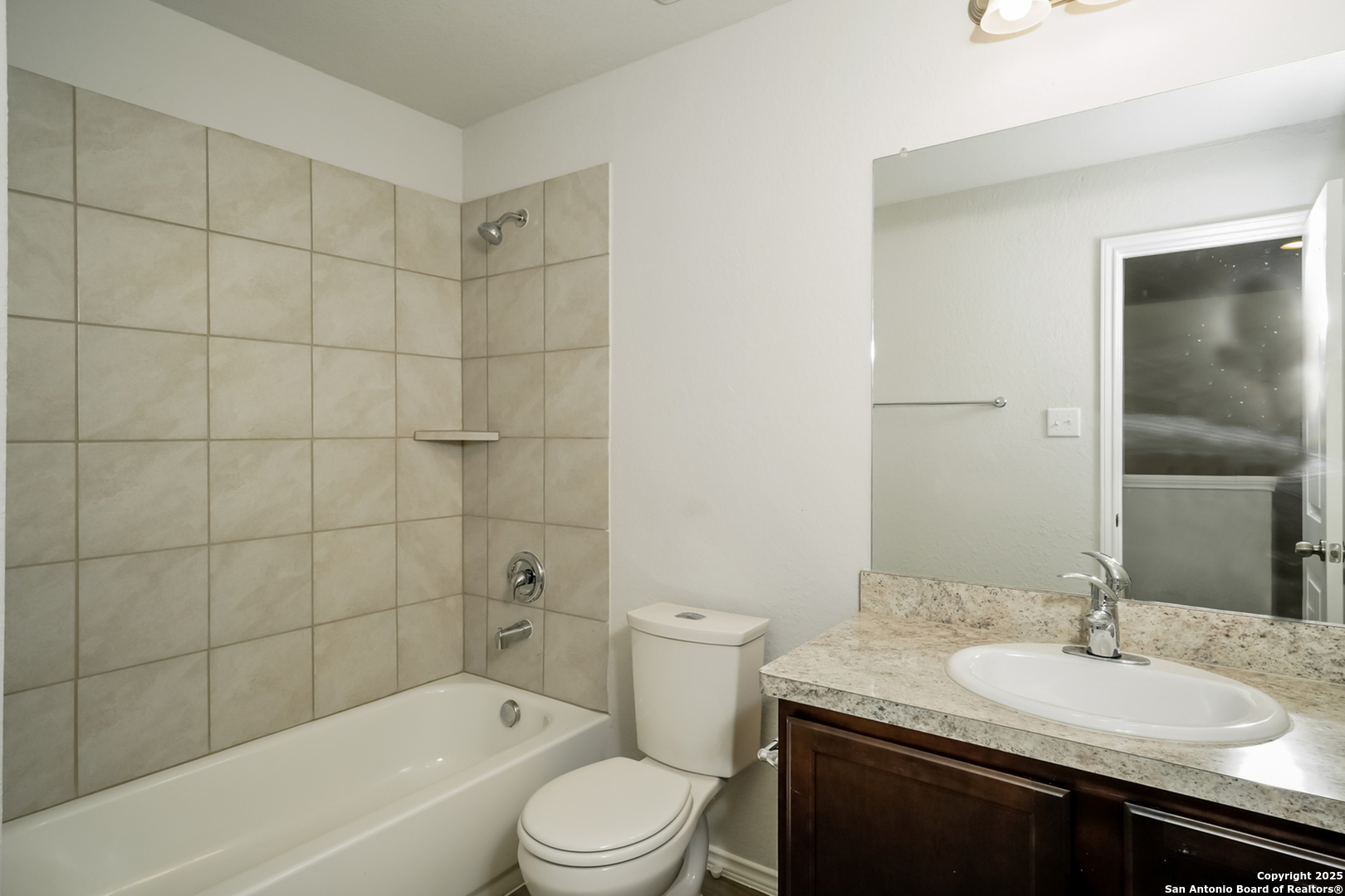 5107 Blue Ranch San Antonio, TX 78222 - Photo 12 of 18 a bathroom with a granite countertop sink a toilet and shower