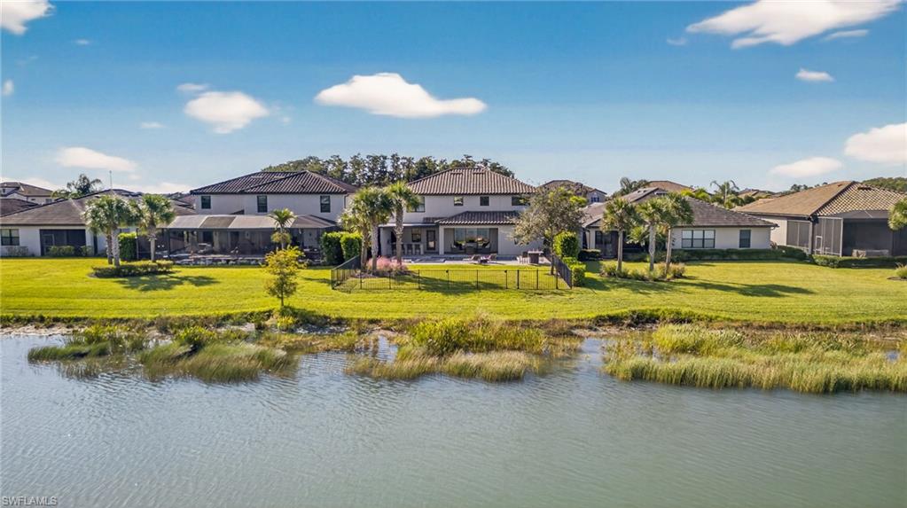 19169 Elston Way Estero, FL 33928 - Photo 37 of 44 a large pool with lawn chairs under an umbrella