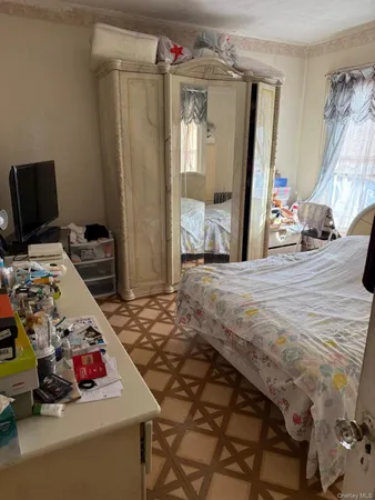 a bedroom with bed and a mirror