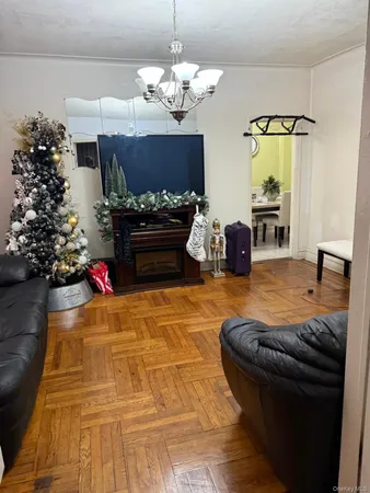 a living room with furniture flowerpot and a chandelier