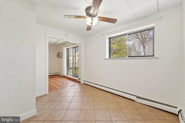 a view of an empty room with a ceiling fan and window