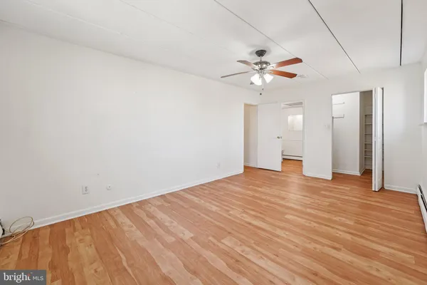 a view of a room with wooden floor and a ceiling fan