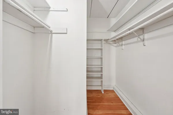 a view of walk in closet with empty racks