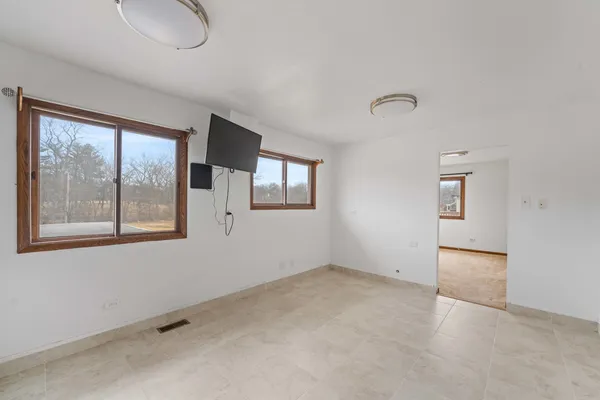 an empty room with windows and cabinet