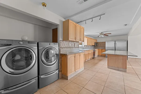 a kitchen with stainless steel appliances granite countertop a sink a stove top oven and cabinets