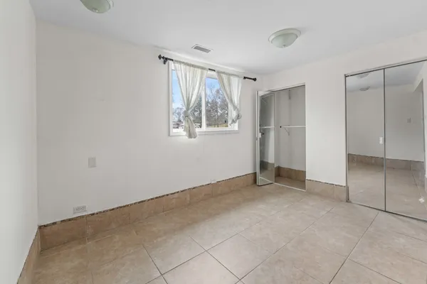 an empty room with windows and closet