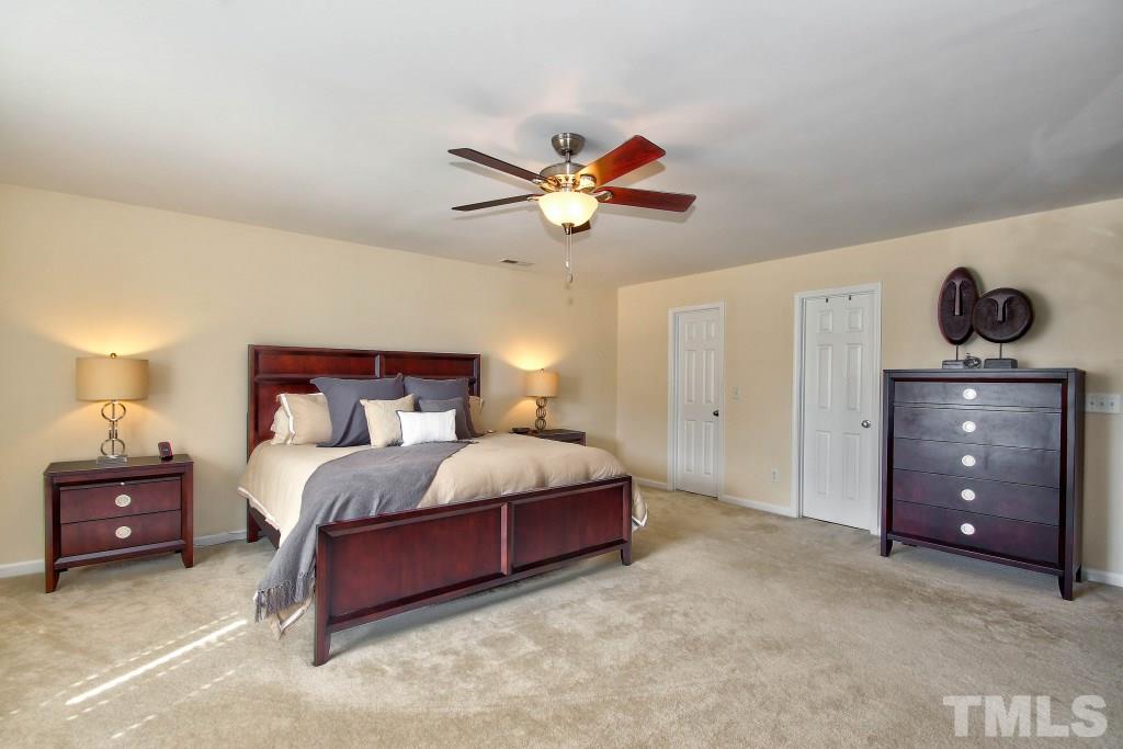 4225 Hopper Street Raleigh, NC 27616 - Photo 14 of 19 a bedroom with a bed and a lamp on a dresser