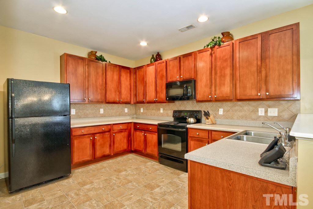 4225 Hopper Street Raleigh, NC 27616 - Photo 6 of 19 a kitchen with stainless steel appliances granite countertop a sink a stove and a refrigerator