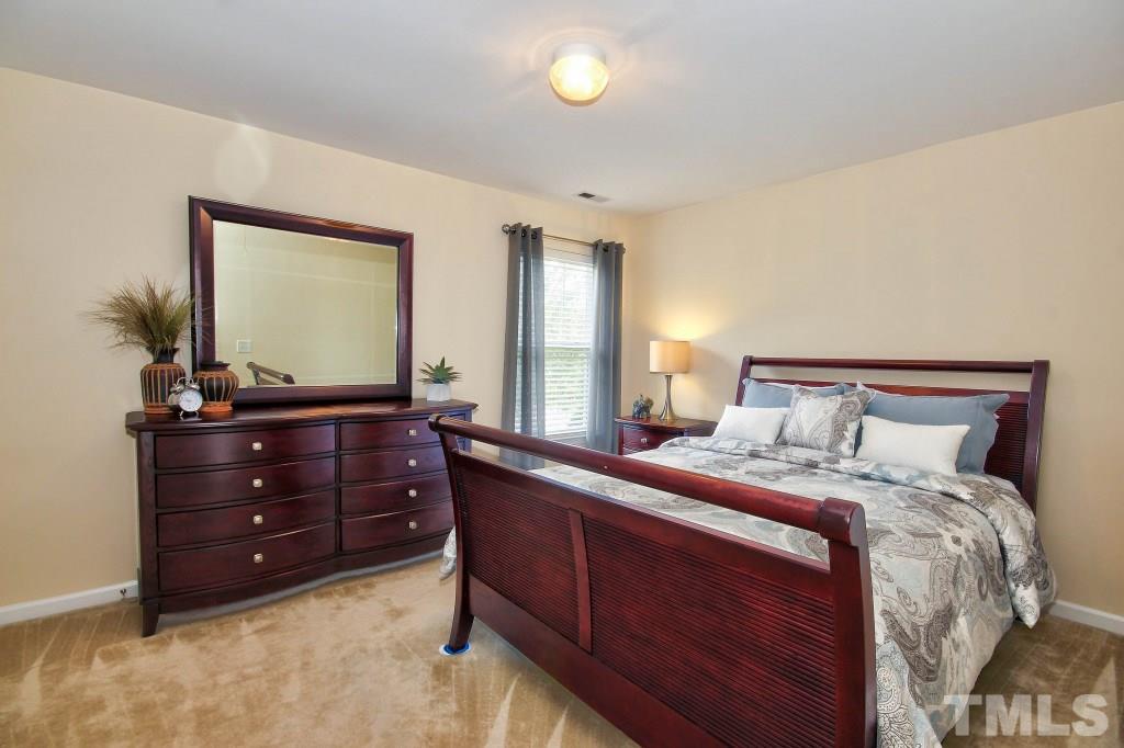 4225 Hopper Street Raleigh, NC 27616 - Photo 10 of 19 a bed room with a bed and a mirror