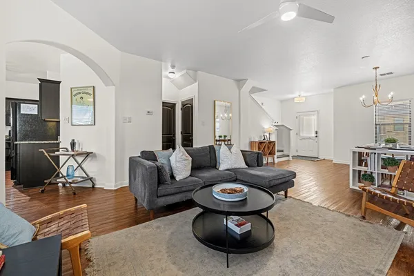 a living room with furniture a flat screen tv and a table