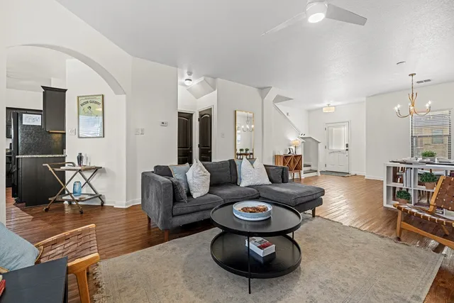 a living room with furniture a flat screen tv and a table