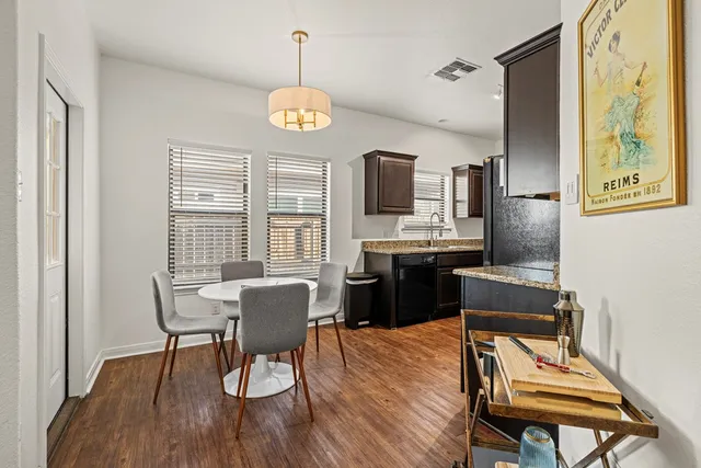 a view of a dining room with furniture a chandelier and wooden floor