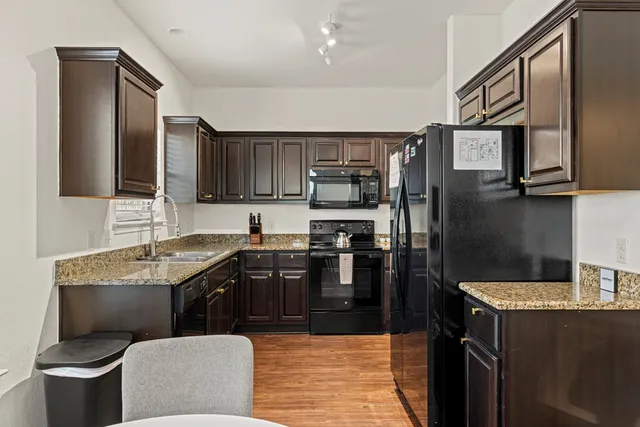a kitchen with stainless steel appliances granite countertop a sink stove and refrigerator