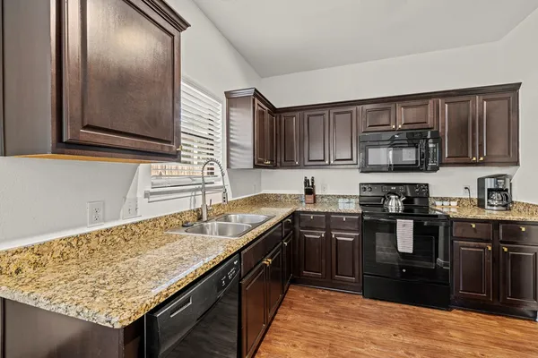 a kitchen with granite countertop stainless steel appliances and wooden cabinets