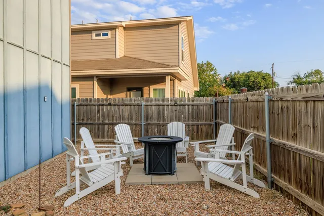 a view of a chairs and table in the back yard of the house