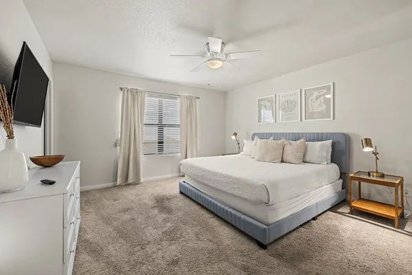 a spacious bedroom with a bed and a flat screen tv