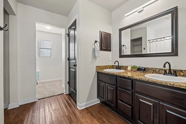a bathroom with a double vanity sink and a mirror