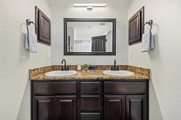 a bathroom with a granite countertop sink and a mirror