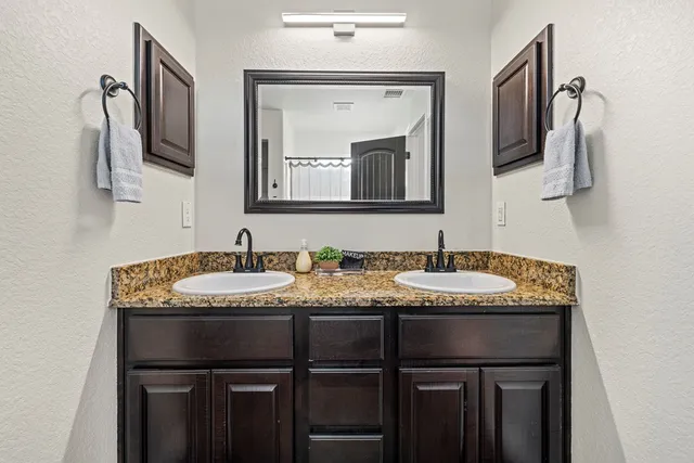 a bathroom with a granite countertop sink and a mirror