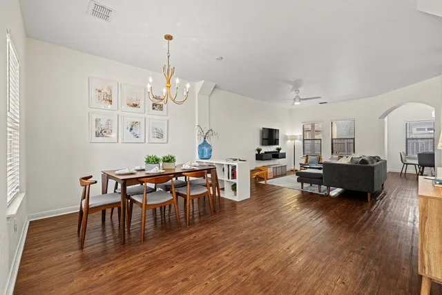 a living room with furniture dining table and a wooden floor