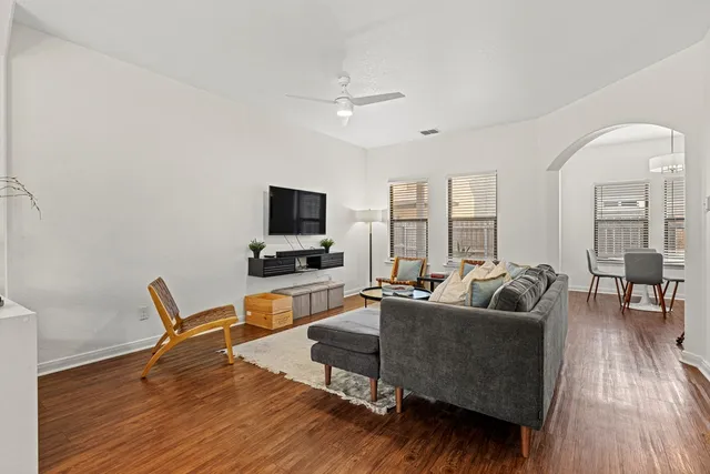 a living room with furniture flat screen tv and wooden floor