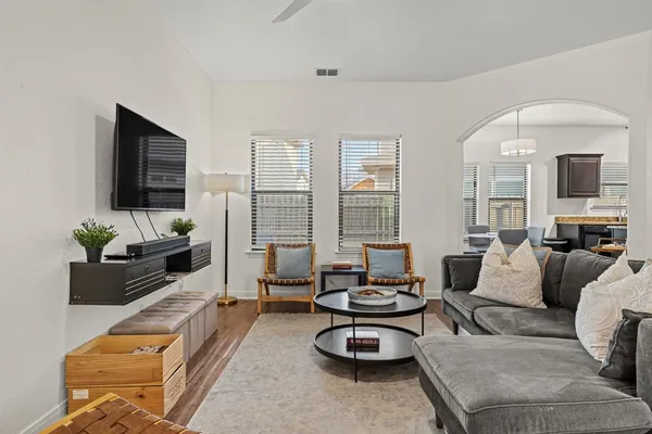 a living room with furniture a flat screen tv and a large window
