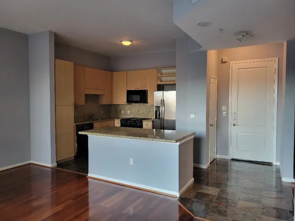 a kitchen with cabinets and wooden floor