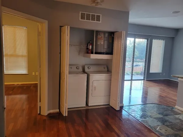 a view of a hallway with wooden floor and a living room