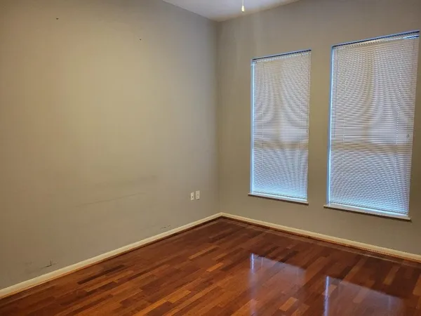 a view of a small space with wooden floor and a window