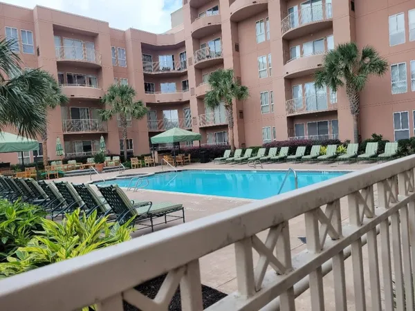 a view of swimming pool with outdoor seating and house in the background