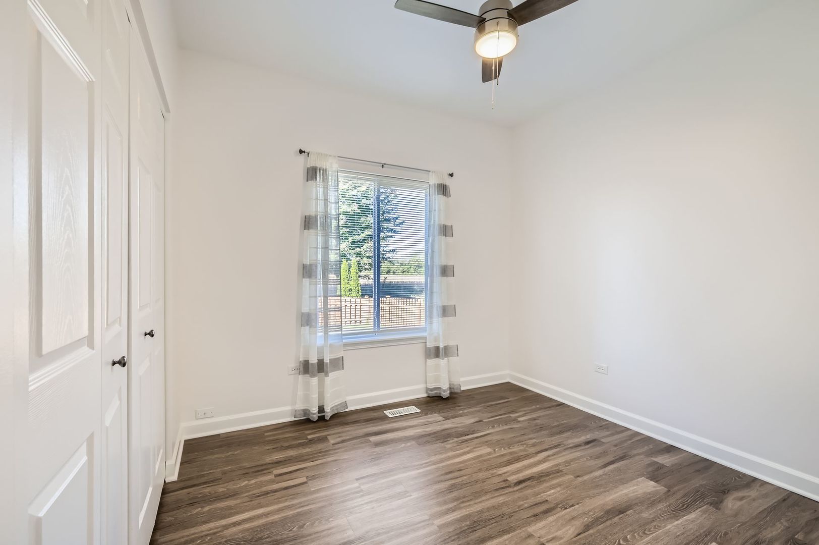 3019 Hoffman Street Plano, IL 60545 - Photo 8 of 10 an empty room with wooden floor fan and windows