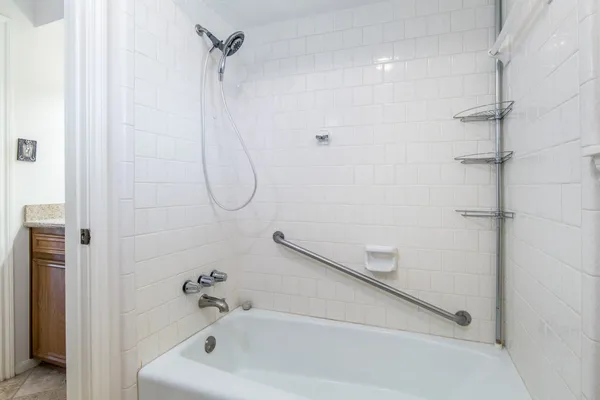 a bathroom with a bath tub with a shower